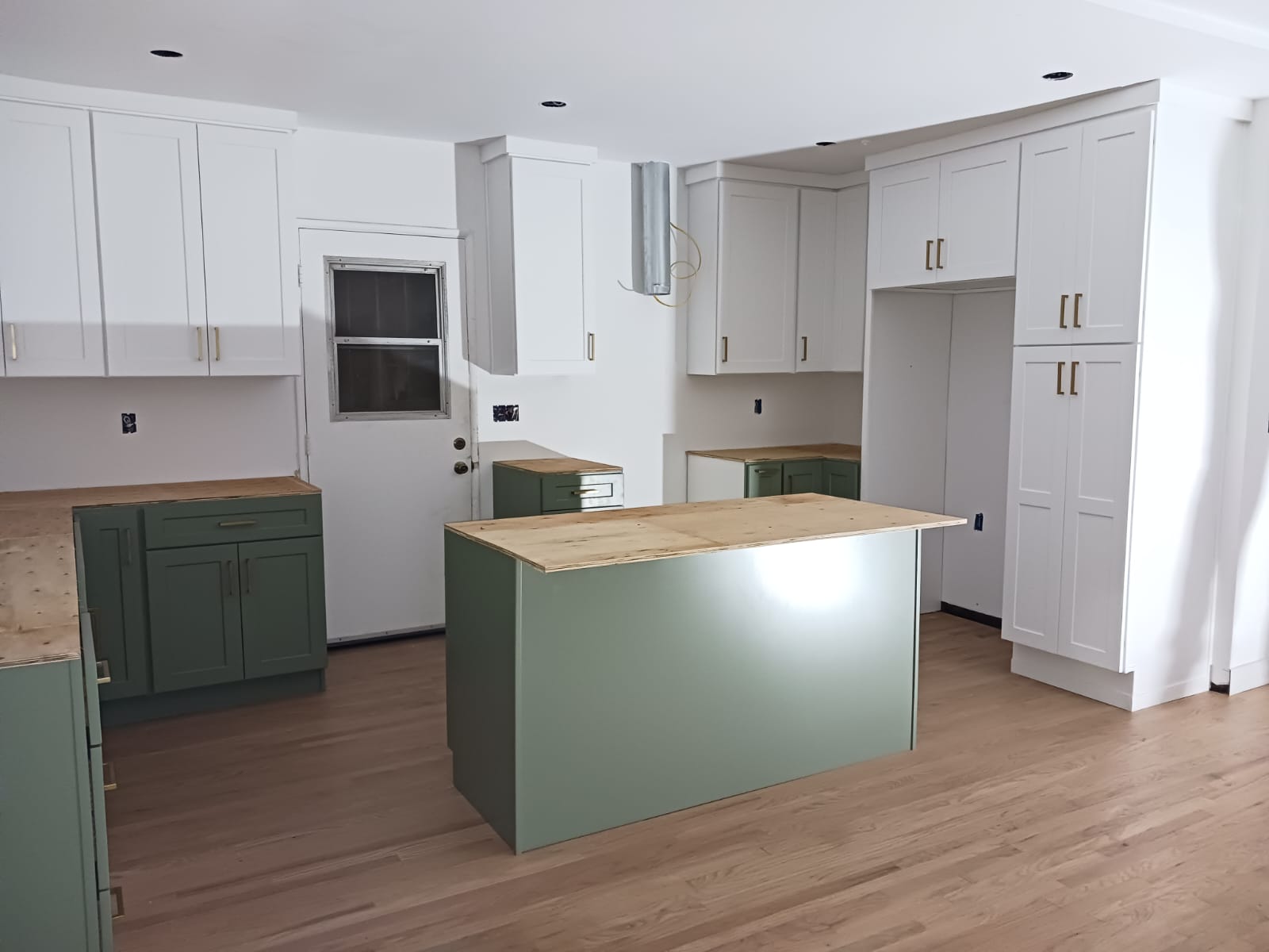 Kitchen remodel in progress with green and white cabinets - Luz Builders